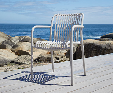 Сірий стілець NABBEN на дерев'яній набережній біля моря