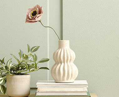 Біла ваза з рожевою паперовою квіткою
