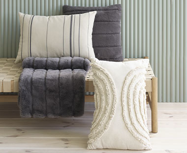 Три декоративні подушки у сірому, бежевому та кольорі тауп на лаві