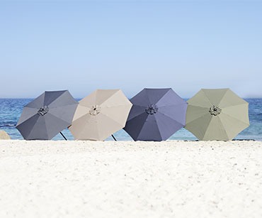 Сіра, бежева, синя і зелена парасольки на пляжі