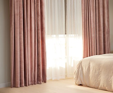 Щільні штори з шторною стрічкою рожевого кольору та легка напівпрозора штора