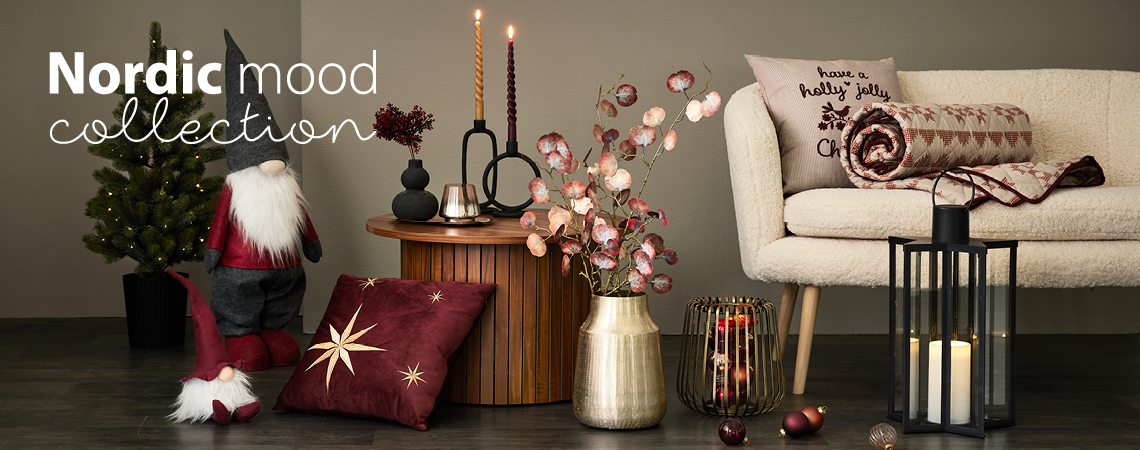 Різдвяні ельфи, подушки, золота ваза зі штучною квіткою, золотий свічник і чорний ліхтар перед білим диваном