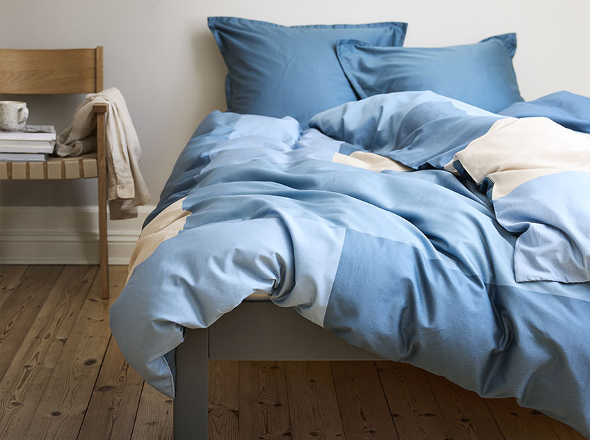 Ліжко з бавовняною постільною білизною у блакитному та пісочному відтінках