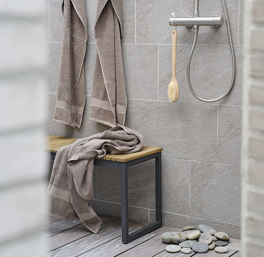 Ванна кімната з лавою, рушниками та щіткою для ванни