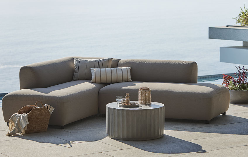 Всесезонний диван для відпочинку в бежевому кольорі та столик для відпочинку на балконі 
