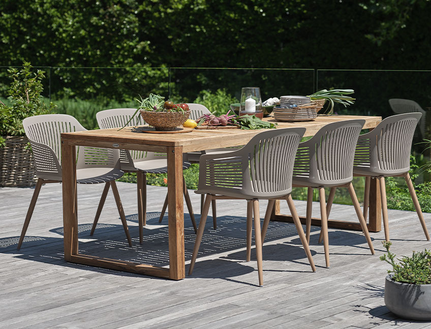Садовий стіл з деревини та садові стільці на патіо