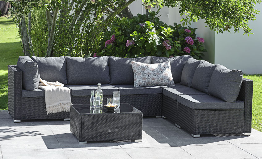 Чорні модульні садові меблі у вигляді двох диванів, які стоять один навпроти одного, розділених столиком для відпочинку