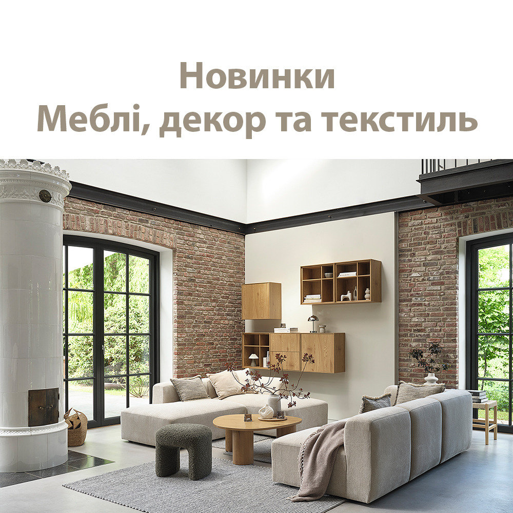 Дивани, столик, пуф та полиці у вітальні з високими вікнами