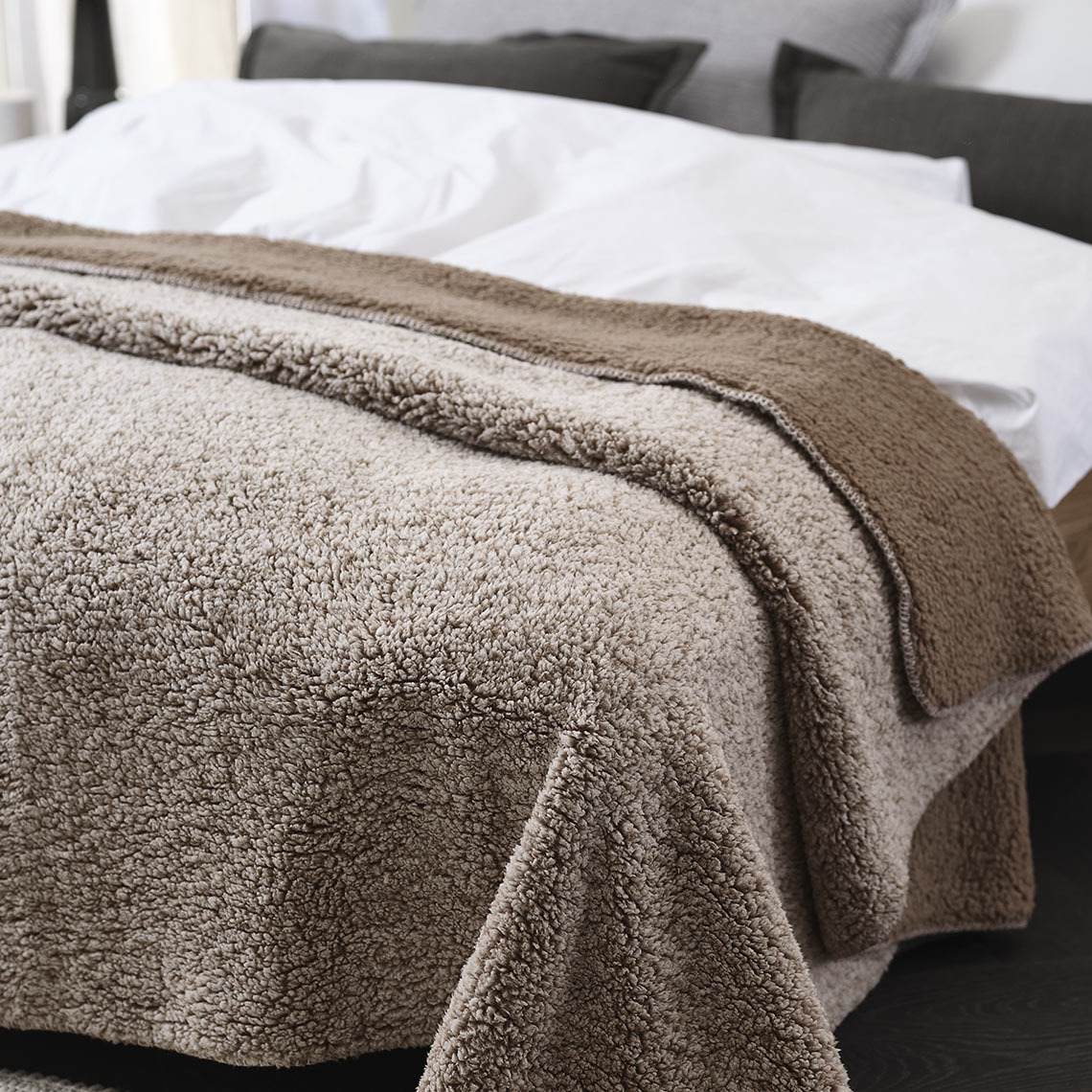 М'який коричневий флісовий плед на ліжку