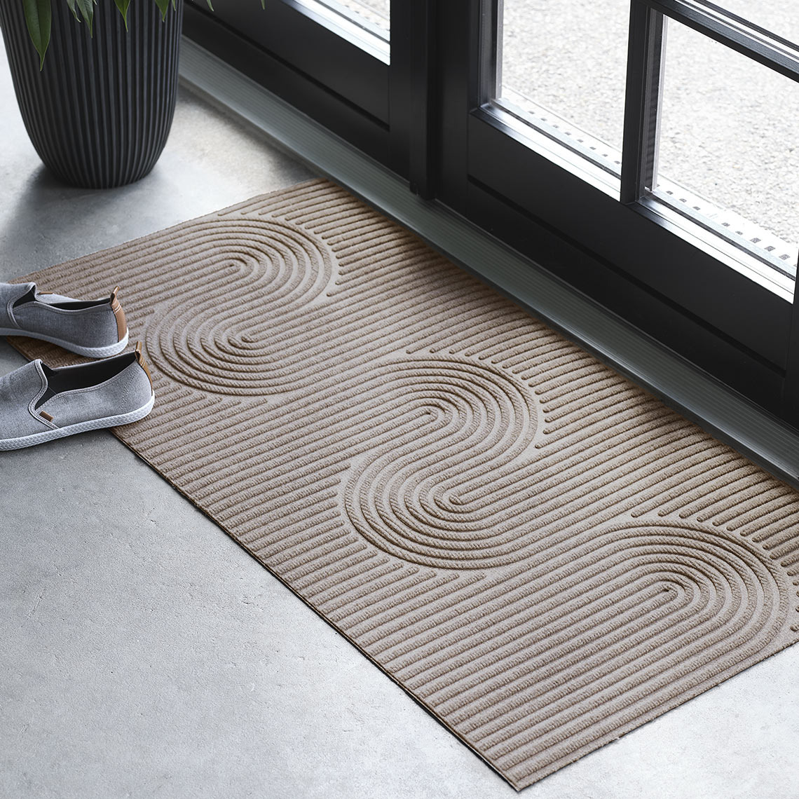 Коричневий прямокутний придверний килимок на вході біля дверей