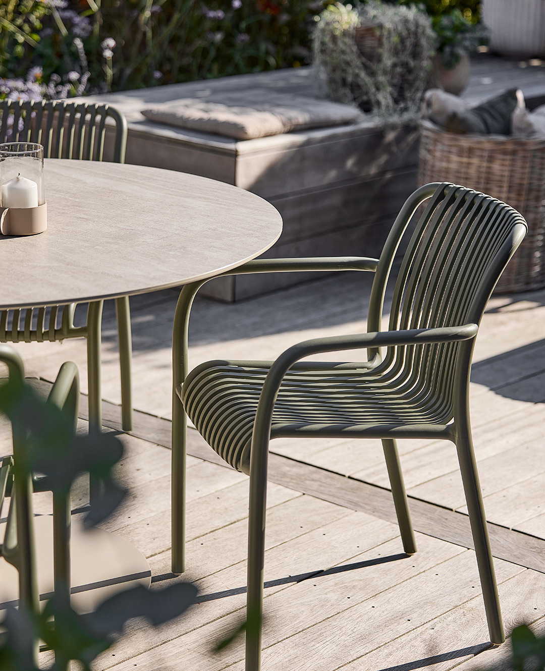 Стілець садовий металевий оливковий біля круглого бежевого столу на терасі