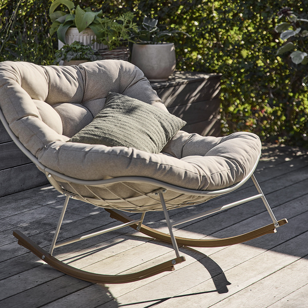 Крісло-гойдалка для саду з м'якими подушками бежевого кольору на терасі