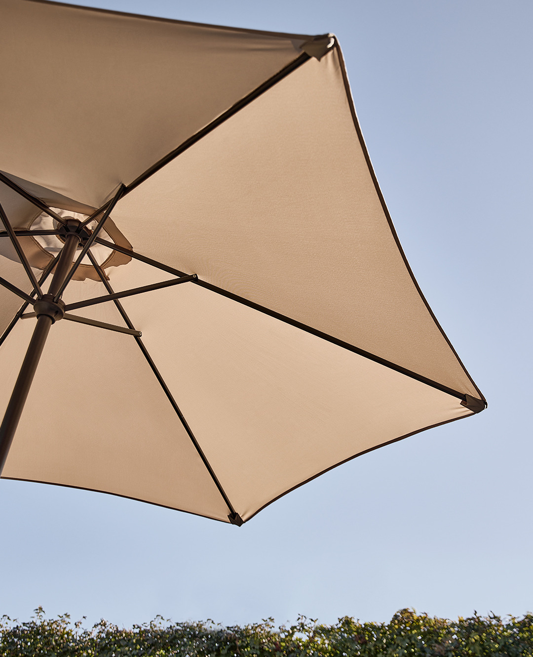 Парасоля садова бежевого кольору на тлі неба