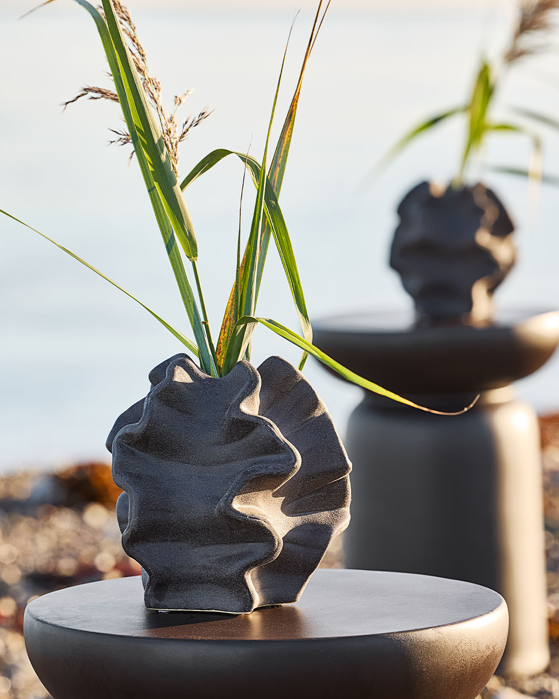 Ваза незвичайної форми на підставці на пляжі