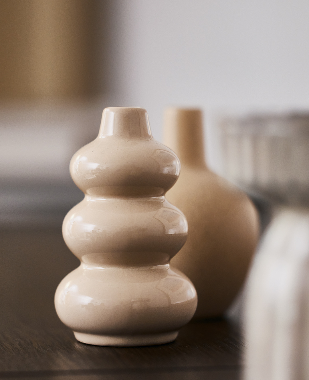 Маленька фігурна бежева ваза на столі