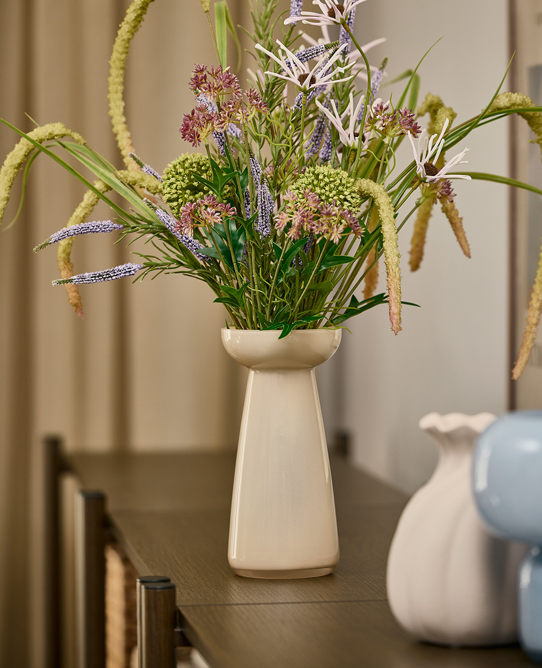 Штучний букет польових квітів у бежевій вазі