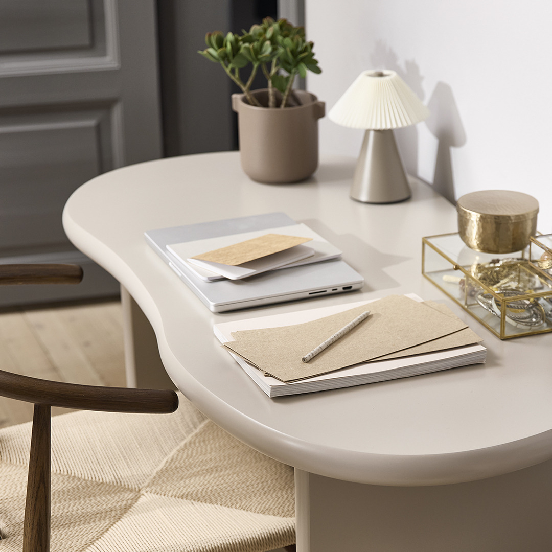 Бежевий стіл офісний овальної форми з нотатником, скриньками для прикрас та лампою