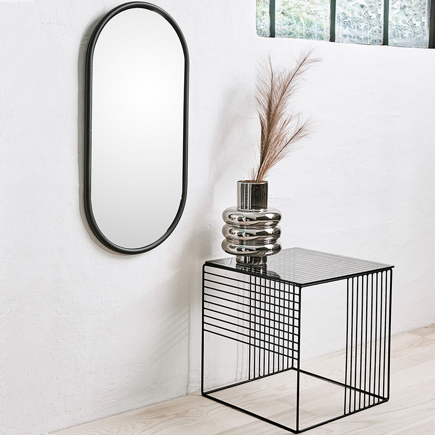 Овальне дзеркало, металевий квадратний столик та срібляста ваза