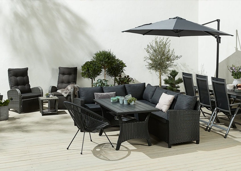 Кутовий комплект садових меблів, поруч чорний стілець та парасоля