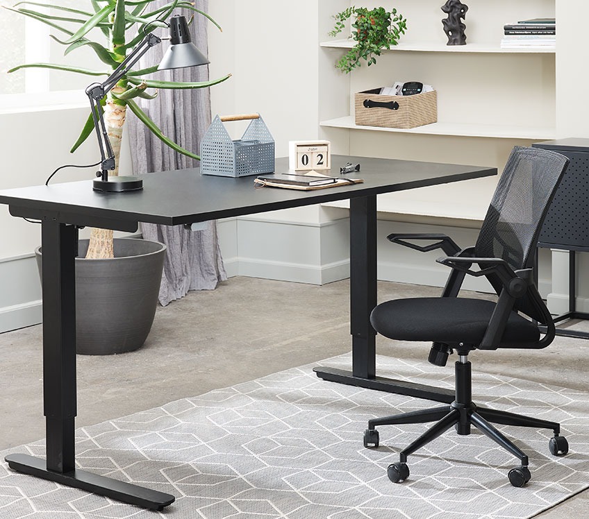 Офісне крісло з сітки за чорним столом з регуляцією висоти