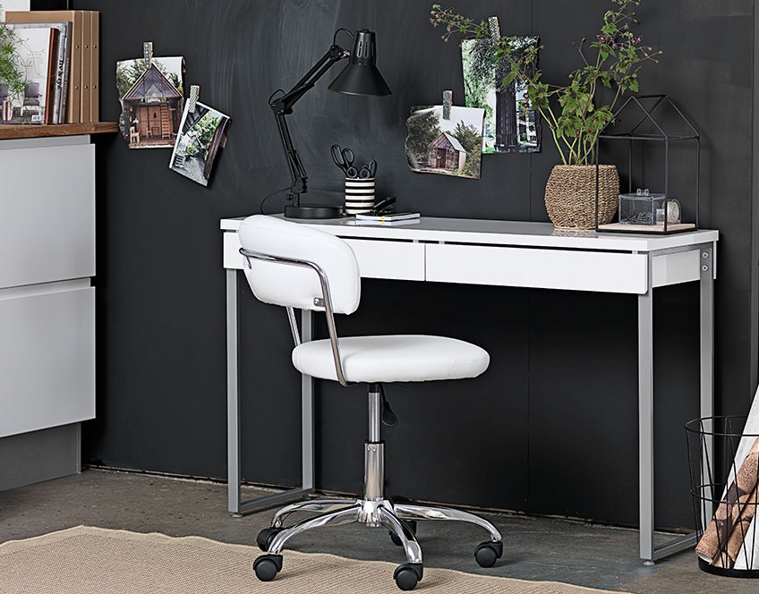Компактний білий стіл з ящиками та білий офісний стілець коло чорної стіни