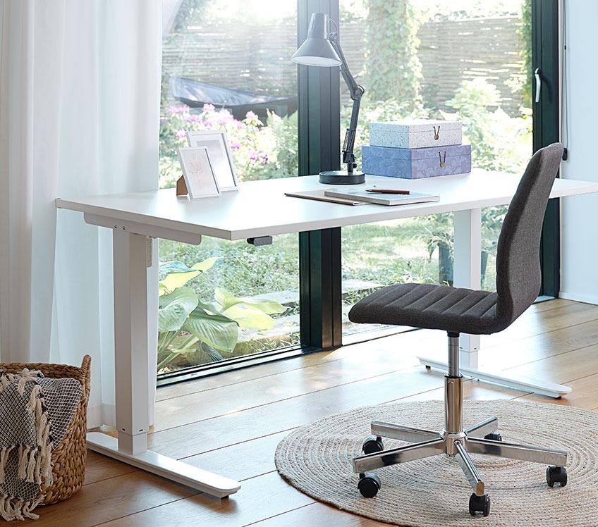 Офісне крісло з тканини за письмовим столом з регуляцією висоти біля вікна