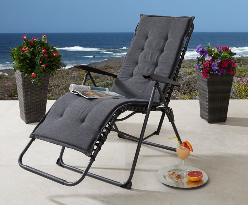 Розкладне крісло з подушкою чорного кольору на терасі