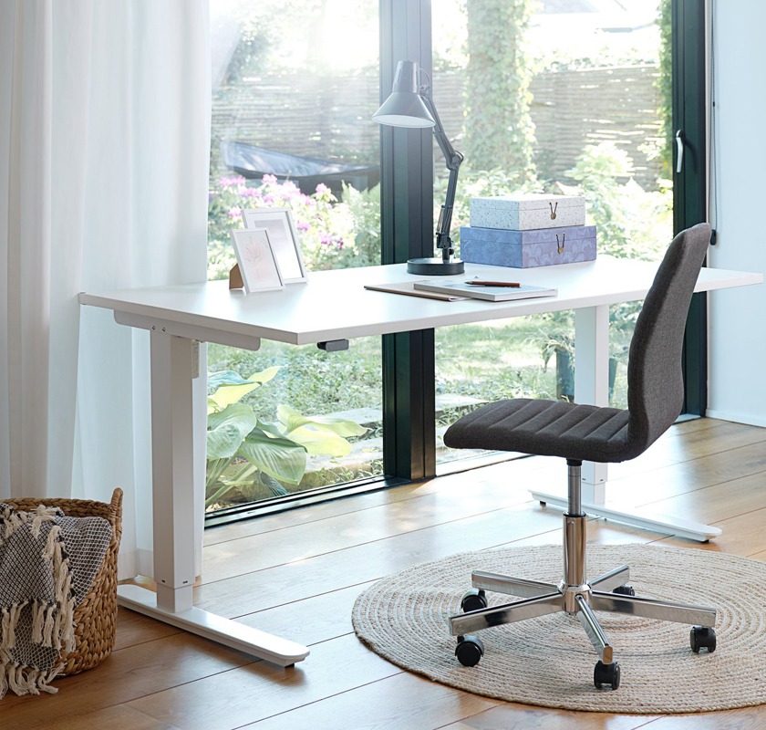Білий письмовий регульований стіл та сіре офісне крісло на балкон