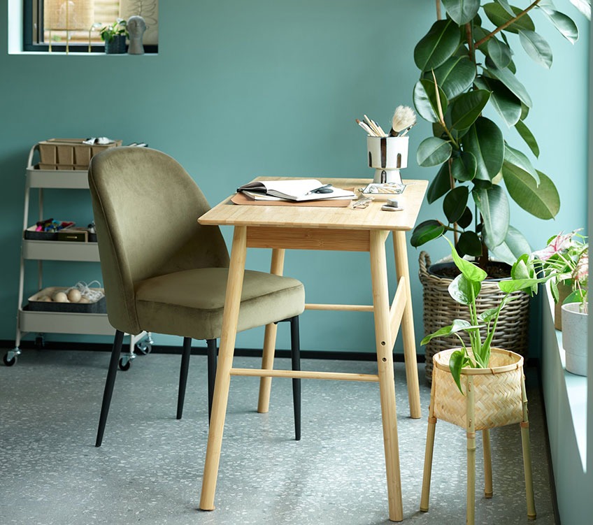 Оливково-зелений обідній стілець біля письмового столу з бамбука
