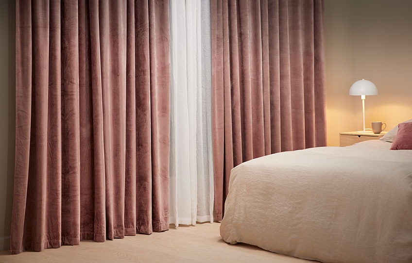 Приватна атмосфера в спальні з затемненими рулонними шторами та важкими шторами