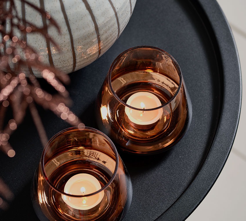 Два скляних свічники на чорному кавовому столі