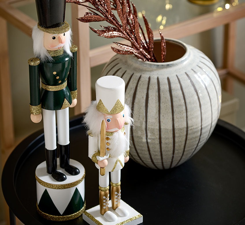 Дві різдвяні статуетки та ваза на чорному кавовому столику