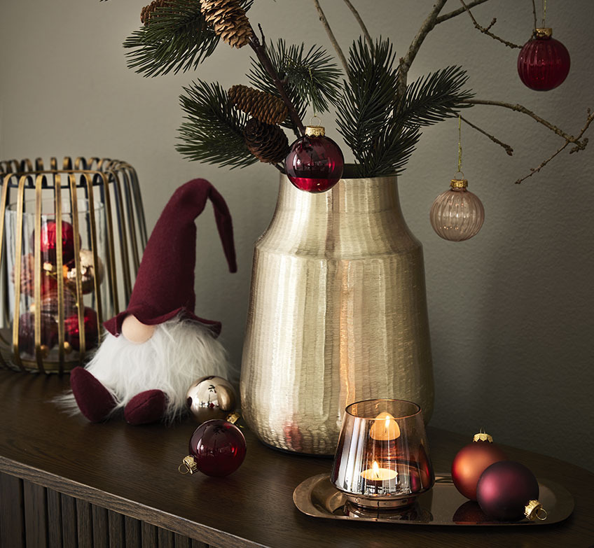 Золотий свічник, різдвяні ельфи та золота ваза з ялиновими гілками та різдвяними дрібничками