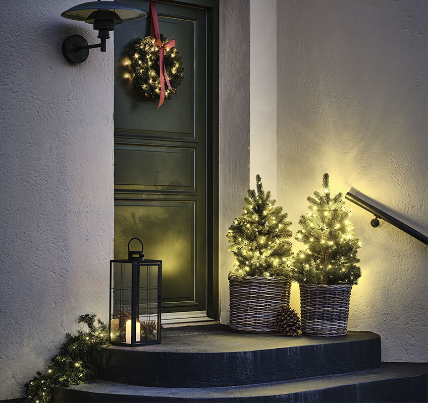 Два дерева-гірлянди перед вхідними дверима і Різдвяний вінок з червоним бантом
