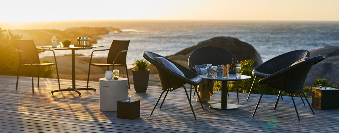 Стіл та стільці для пляжної вечірки на терасі на заході сонця