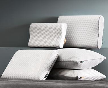Спеціальні подушки з ефектом пам'яті бренду WELLPUR різних розмірів та форм, складені одна на одну