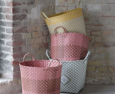 Плетені різнокольорові кошики рожевого, жовтого та блакитного кольорів